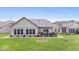 Brick home's backyard with a patio that includes outdoor furniture and a manicured lawn at 4134 Bella Ct, Indianapolis, IN 46237
