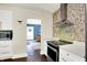 Modern kitchen with stainless steel appliances, mosaic backsplash, and dark hardwood floors, offering a sleek design at 4527 Central Ave, Indianapolis, IN 46205