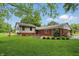 A view of the backyard featuring an outdoor patio, a large shade tree and beautiful lawn at 5129 E 69Th St, Indianapolis, IN 46220