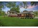 A backyard with large shade tree and large lawn with home exterior in the background at 5129 E 69Th St, Indianapolis, IN 46220