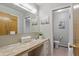 Bright bathroom with a large mirror over a pink marble countertop, and an adjacent water closet at 5129 E 69Th St, Indianapolis, IN 46220