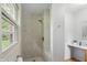 Shower with a window providing natural light and a vanity area next to the walk-in shower at 5129 E 69Th St, Indianapolis, IN 46220