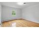 Bright bedroom featuring hardwood floors, a window overlooking the yard, and neutral paint at 5129 E 69Th St, Indianapolis, IN 46220