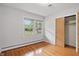 Bedroom featuring hardwood floors, closet, and a window overlooking the front yard at 5129 E 69Th St, Indianapolis, IN 46220