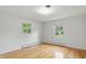 Inviting bedroom with hardwood floors, a ceiling light, and windows showcasing serene outdoor views at 5129 E 69Th St, Indianapolis, IN 46220