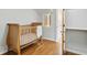 Bedroom featuring hardwood floors, a baby crib, and natural light at 5129 E 69Th St, Indianapolis, IN 46220