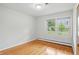 Bright bedroom featuring hardwood floors, a window overlooking the yard, and neutral paint at 5129 E 69Th St, Indianapolis, IN 46220