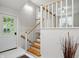 Bright entryway with wooden stairs and a white front door, creating a welcoming entrance to the home at 5129 E 69Th St, Indianapolis, IN 46220