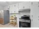 This kitchen features stainless steel appliances, white cabinets, and a charming wooden storage cart at 5129 E 69Th St, Indianapolis, IN 46220