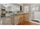 A charming eat-in kitchen showcases ample white cabinetry, a breakfast bar with seating, and easy access to the staircase at 5129 E 69Th St, Indianapolis, IN 46220