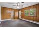 A cozy room features knotty wood paneling, a ceiling fan, multiple windows, and access to the laundry room at 5129 E 69Th St, Indianapolis, IN 46220