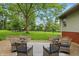 Brick patio surrounded by lawn with stylish furniture and a mature shade tree at 5129 E 69Th St, Indianapolis, IN 46220