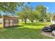 Backyard featuring a shed, patio, and a large grassy area surrounded by trees at 518 N Carr Rd, Plainfield, IN 46168