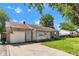 Charming home with an attached garage, an American flag, and a well-manicured lawn under a clear, blue sky at 518 N Carr Rd, Plainfield, IN 46168