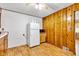 Eat-in kitchen with linoleum floors, wood paneling, and a white refrigerator at 518 N Carr Rd, Plainfield, IN 46168
