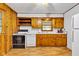 Eat-in kitchen with linoleum floors, wood cabinets, and white appliances at 518 N Carr Rd, Plainfield, IN 46168