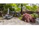 Landscaped backyard featuring flagstone patio with seating, mature trees, and privacy at 5219 N New Jersey St, Indianapolis, IN 46220