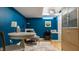 Eclectic basement featuring blue walls, a unique rug, modern furniture, and stylish storage at 5219 N New Jersey St, Indianapolis, IN 46220