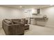 Cozy basement featuring a comfortable gray sectional, carpeted floors, and a mini bar at 5219 N New Jersey St, Indianapolis, IN 46220