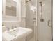 Bright bathroom with white tiled shower, classic sink, and mirrored medicine cabinet at 5219 N New Jersey St, Indianapolis, IN 46220