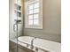 Elegant bathroom with a sleek soaking tub, modern fixtures, and convenient built-in shelving at 5219 N New Jersey St, Indianapolis, IN 46220