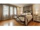 Inviting bedroom with hardwood floors, soft curtains, and a comfortable bed with stylish wrought iron frame at 5219 N New Jersey St, Indianapolis, IN 46220