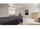 Bright bedroom features a bed with a blue quilt, natural wood furnishings and an integrated shelving and entertainment area at 5219 N New Jersey St, Indianapolis, IN 46220