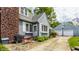 Charming home with stone walkway, detached garage, landscaped yard, brick chimney, outdoor seating at 5219 N New Jersey St, Indianapolis, IN 46220