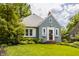 Well-kept blue home with a lush green lawn, perfectly trimmed bushes, and a quaint front entrance at 5219 N New Jersey St, Indianapolis, IN 46220