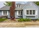 Exterior view of home featuring brick chimney, charming windows, and inviting patio at 5219 N New Jersey St, Indianapolis, IN 46220