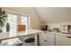 Bright home office featuring a white desk, stool, storage cabinets, and a large window with natural light at 5219 N New Jersey St, Indianapolis, IN 46220