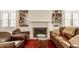 Cozy living room featuring a fireplace with bookshelves, leather furniture, and hardwood floors at 5219 N New Jersey St, Indianapolis, IN 46220