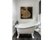 Elegant bathroom features a classic clawfoot tub and stylish dark fixtures beneath artwork at 5280 N Capitol Ave, Indianapolis, IN 46208
