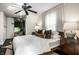 Bedroom featuring a large bed, ceiling fan, bedside tables with lamps, and wood floors at 5280 N Capitol Ave, Indianapolis, IN 46208