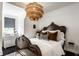 Cozy bedroom featuring a decorative chandelier and an ornate, vintage-style wood-framed bed at 5280 N Capitol Ave, Indianapolis, IN 46208