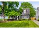 Charming house with a well-maintained lawn, lush tree, and classic architectural details at 5280 N Capitol Ave, Indianapolis, IN 46208