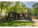 Back exterior view showcasing mature trees, covered porch and a well-maintained yard at 5280 N Capitol Ave, Indianapolis, IN 46208