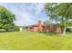 Backyard view featuring the exterior of the home with lush green grass, mature trees, and landscaping at 5457 W 900 North, McCordsville, IN 46055