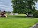 Expansive backyard features a playset, a storage shed, and mature trees, perfect for outdoor activities at 5457 W 900 North, McCordsville, IN 46055