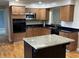 Well-equipped kitchen with a granite island, stainless steel microwave, and wooden cabinetry at 5457 W 900 North, McCordsville, IN 46055