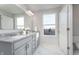 Bright bathroom featuring double sinks, granite countertops, stylish fixtures, and a large window at 591 Dalton Way, Avon, IN 46123