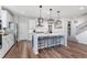 Bright kitchen features a large island, stylish pendant lighting, stainless steel appliances, and hardwood flooring at 591 Dalton Way, Avon, IN 46123