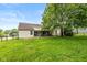 Spacious backyard with green grass, patio, and tall mature tree providing shade at 6138 Bartley Ct, Indianapolis, IN 46236