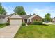Charming single-story home featuring brick and vinyl siding, a two-car garage, and a well-manicured lawn at 6138 Bartley Ct, Indianapolis, IN 46236
