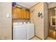 Bright laundry room featuring brick accent wall, cabinets, and appliances at 6138 Bartley Ct, Indianapolis, IN 46236