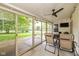 Covered sunroom with ceiling fan and views of the landscaped yard, featuring chairs and a bbq at 6138 Bartley Ct, Indianapolis, IN 46236