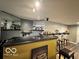 Basement bar area with a black bar top, seating, and shelving filled with beverages at 6155 W Bayfront, McCordsville, IN 46055