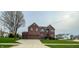 Charming two-story red brick home with a three-car garage and well-manicured front lawn at 6155 W Bayfront, McCordsville, IN 46055