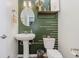 Stylish half bath features decorative green walls, a pedestal sink, and modern fixtures at 6460 Wasco Dr, Whitestown, IN 46075