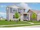 Well-kept lawn of a two-story home featuring stone accents, blue siding and a cozy front porch area at 6460 Wasco Dr, Whitestown, IN 46075